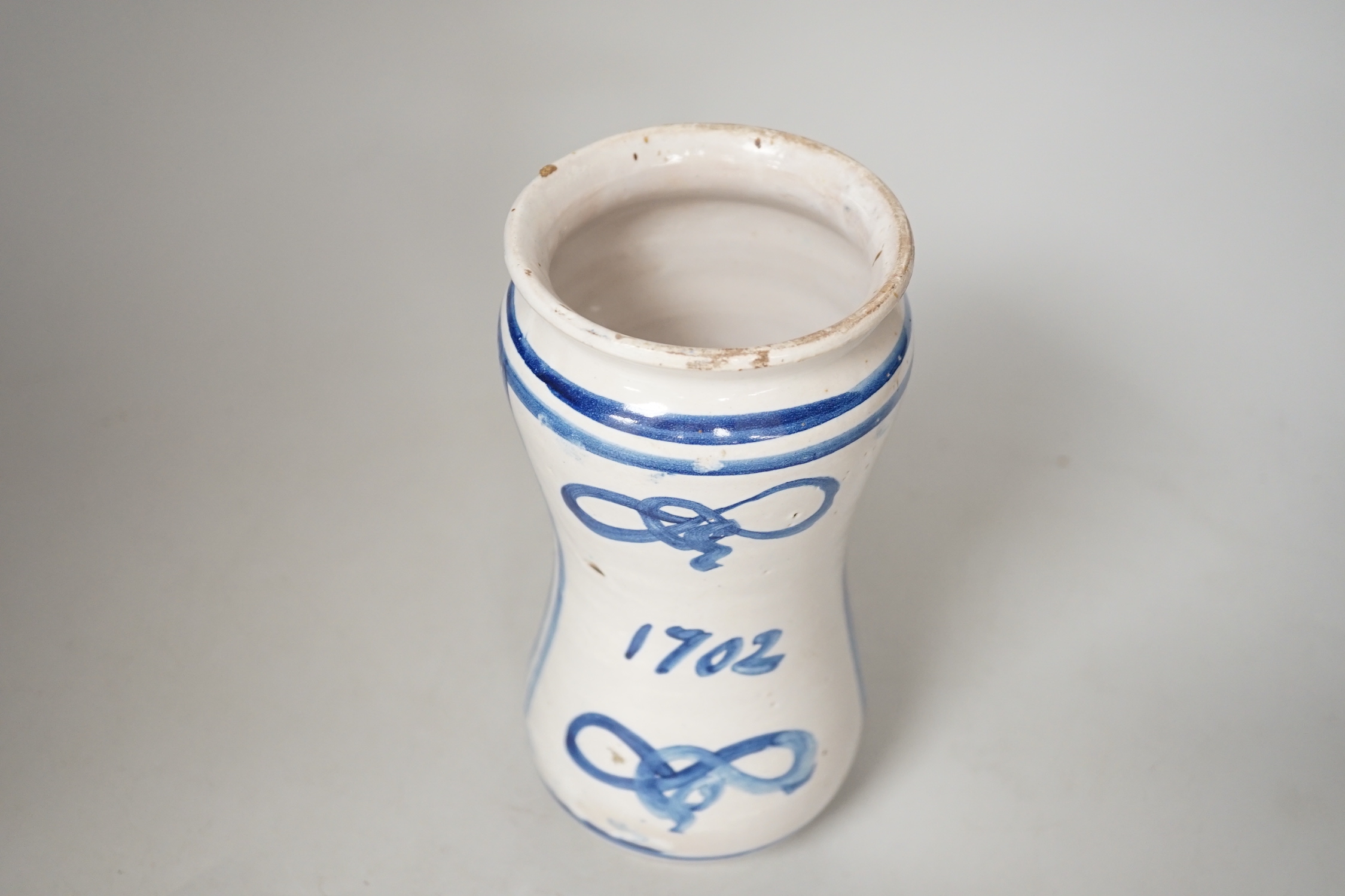 An Italian maiolica albarello, inscribed 1702, 20.5cm high